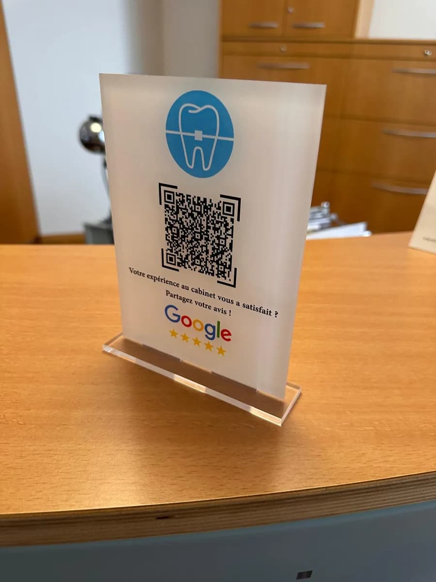 Chevalet SwissQR transparent posé sur le bureau d'accueil d'un cabinet d'orthodontie